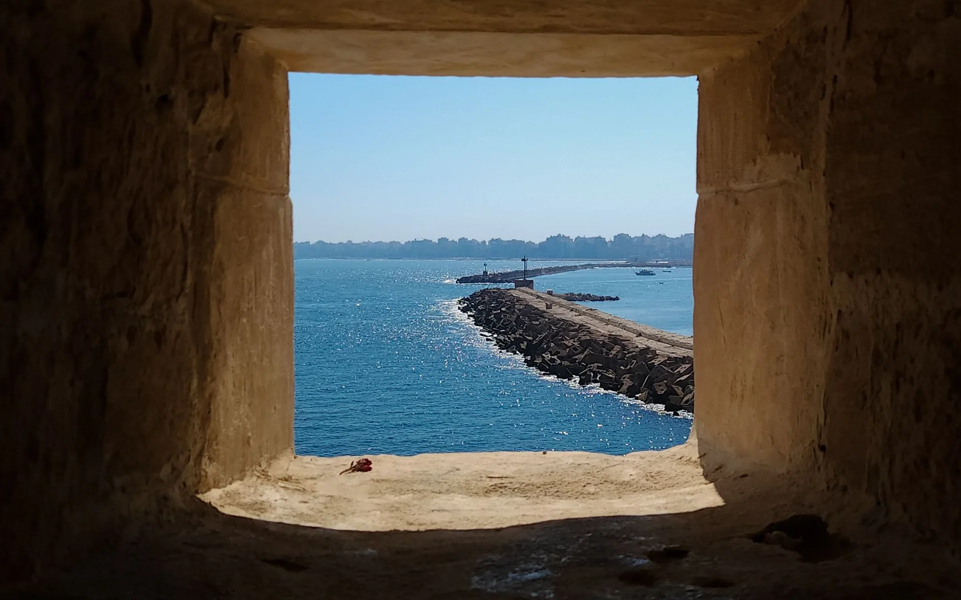 Vista para o mar através de uma janela histórica de pedra em Alexandria