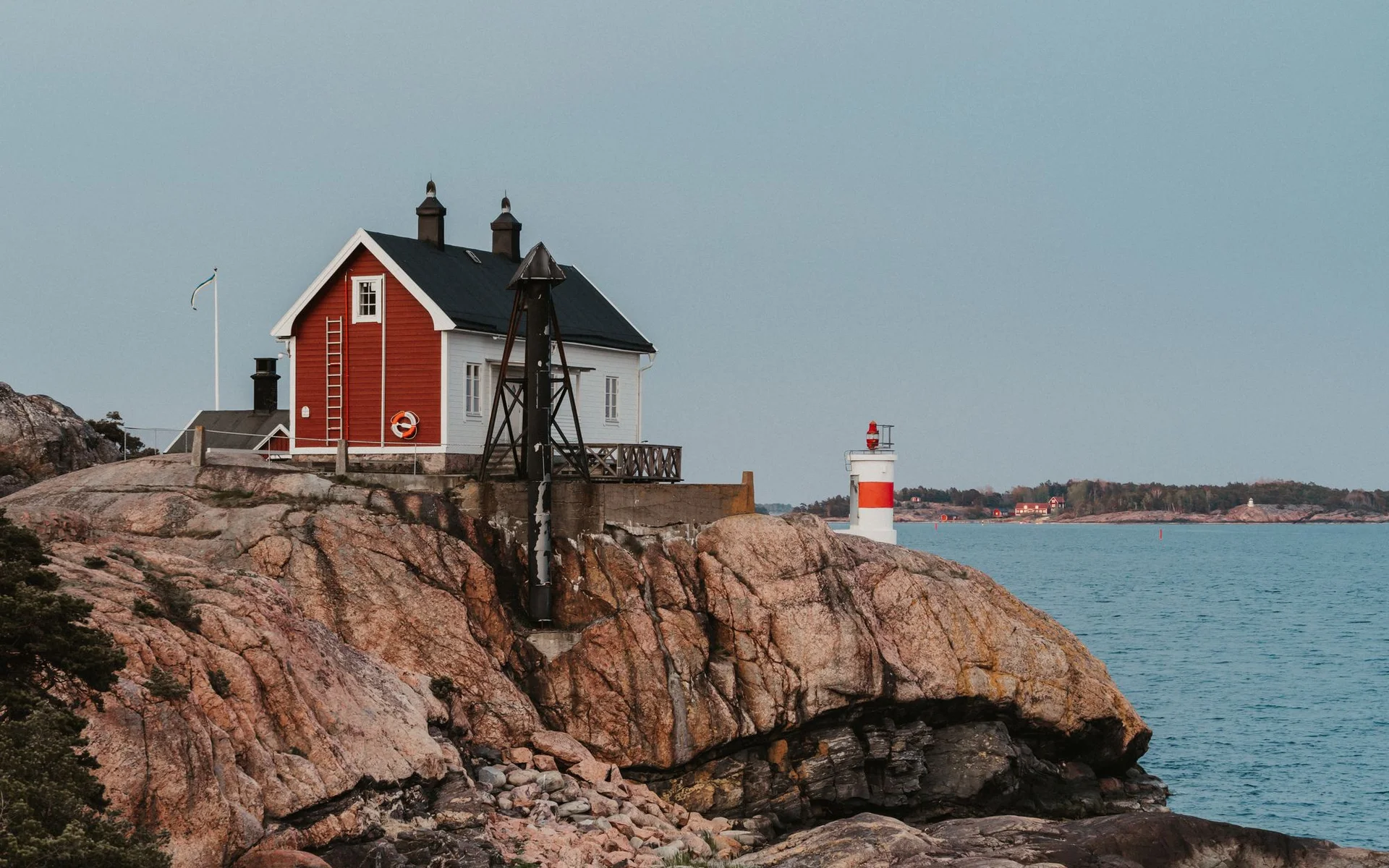 Casa Vermelha e Farol na costa rochosa da Suécia