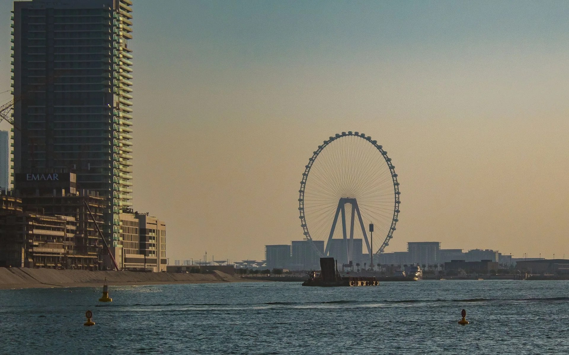 Skyline do Dubai com a roda gigante ao pôr-do-sol